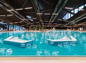 una piscina con acqua blu in un edificio di Hotel Well Family a Tuheljske Toplice