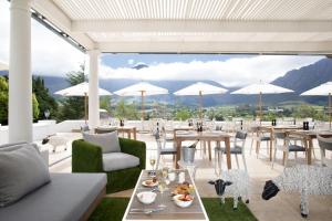a patio with tables and chairs and umbrellas at Mont Rochelle in Franschhoek