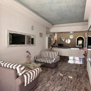 a living room with two couches and a television at Strand Hotel in Gabicce Mare