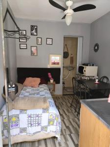 a bedroom with a bed and a kitchen with a table at Família Durães Kitnets02 in Londrina