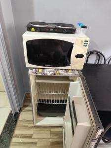 a microwave oven sitting on top of a table at Família Durães Kitnets02 in Londrina