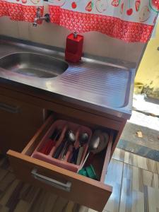 a kitchen counter with a sink and a drawer with utensils at Família Durães Kitnets02 in Londrina