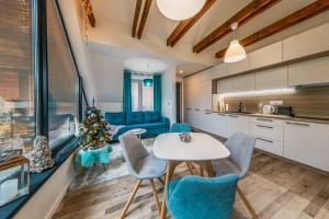 a kitchen and living room with a table and chairs at 3 Apartmány SKI Jasná in Demanovska Dolina