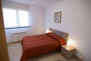 1 dormitorio con 1 cama grande con manta roja en Apartament Bagà, en Bagá