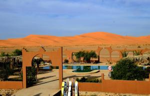 a resort in the desert with a swimming pool at Kasbah Du Berger & Piscine in Merzouga