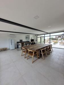 a large room with a large wooden table and chairs at Alquiler De Departamento Monoambiente Con Terraza, Frente Al Mar En La Costa Quequén, Con Pileta, Solarium y Sum Con Parrilla in Quequén
