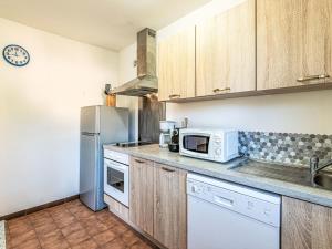 una cocina con microondas y nevera en Apartment T2 Gabriello by Interhome, en Cala dʼOro