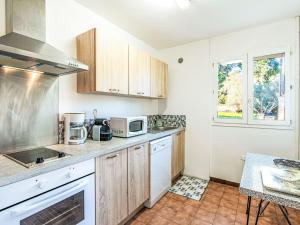 Una cocina con gabinetes de madera y encimera. en Apartment T2 Gabriello by Interhome, en Cala dʼOro