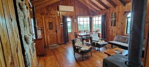 a living room with wooden walls and wooden floors at Agroturismo los Colihues in Castro
