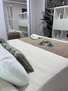 a bed with white sheets and pillows in a room at Appartamento Oceano - Playa San Juan in Playa de San Juan