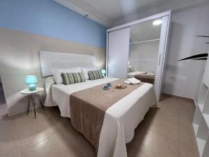 a bedroom with a bed with a table and a mirror at Appartamento Oceano - Playa San Juan in Playa de San Juan