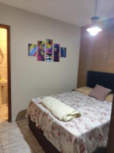 a bedroom with a bed with a blanket on it at Família Durães Kitnets03 in Londrina