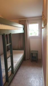 une chambre avec deux lits superposés et une fenêtre dans l'établissement villa les bastides de l olivier grau du roi, au Grau-du-Roi 14 autres photos