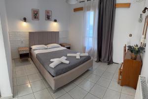 a bedroom with a bed with two white towels on it at Oscar Hotel Lefkada in Nydri