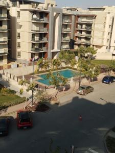 ein Parkplatz mit vor einem Gebäude geparkten Autos in der Unterkunft Rental apartment in new Cairo شقة لك بالكامل in Kairo