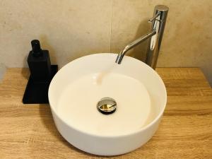 un fregadero blanco con un grifo sobre una mesa de madera en Maison du Château Sarre, en Aosta 5 fotos más