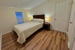 Un dormitorio con una cama grande y suelo de madera. en Cozy and quiet four Four Pets Yes, en Beaufort