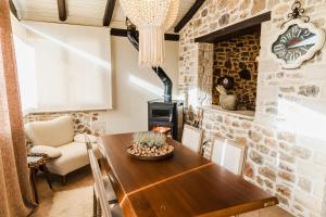 a dining room with a wooden table and a wood stove at Μάραθος in Kalavrita