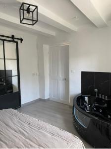 a bedroom with a bed and a black tub at Le Mas du Bueysse in Bessas