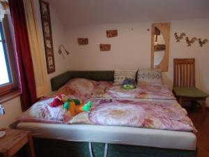 ein Bett mit zwei ausgestopften Tieren, die darauf liegen in der Unterkunft Casa Sauschneider in Sankt Ruprecht ob Murau