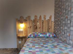 a bedroom with a bed with a wooden wall at Casa tio peguero - piscina spa in San Bartolomé de Pinares