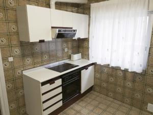 a kitchen with white cabinets and a black stove top oven at Casa tio peguero - piscina spa in San Bartolomé de Pinares +12 photos