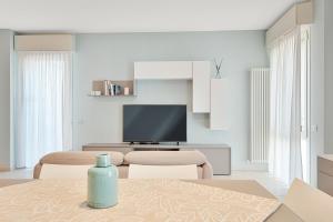 a living room with a table and a television at Levante Appartamento di pregio, terrazza e vista panoramica sul mare e la città in Viareggio