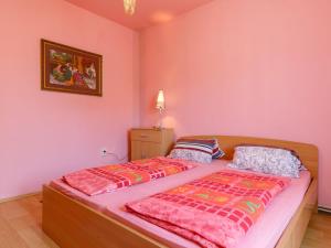 - 2 lits dans une chambre aux murs roses dans l'établissement Apartment Keszeg-2 by Interhome, à Balatonkeresztúr