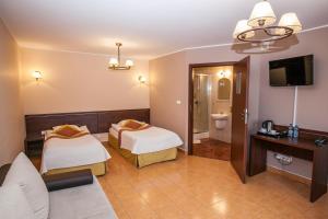 a hotel room with two beds and a television at Miłocin Park Centrum Wypoczynkowo-Konferencyjne in Pierwoszów +33 photos