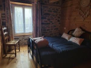 a bedroom with a bed in a room with a window at Maison 4 à 9 personnes à la campagne in Alleuze