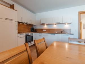 a kitchen with white cabinets and a wooden table at Apartment Talmoosen-Bauer by Interhome in Dorf