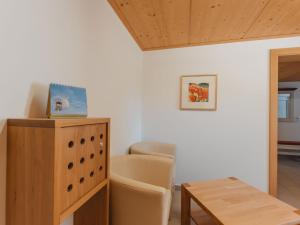 a room with a table and a chair and a wooden cabinet at Apartment Talmoosen-Bauer by Interhome in Dorf +31 photos