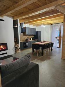 a kitchen and living room with a table and chairs at Domek Pod Skarpą in Wieprzec