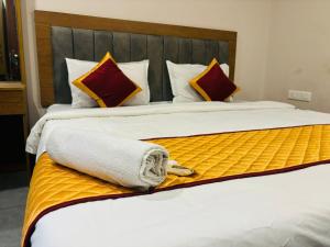 Bett mit weißer Bettwäsche und roten Kissen in der Unterkunft Hotel StayInn in Kozhikode