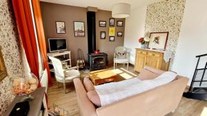 a living room with a couch and a tv at Le blason in Rosult