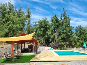 a gazebo next to a swimming pool at Cabañas Alto Quillay, radal siete tasas in El Torreón