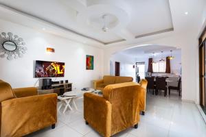 a living room with a couch and chairs and a table at Becky Homes Diani Beach- 4BR with AC and Swimming Pool in Diani Beach