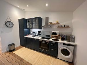 a kitchen with a stove and a washing machine at Le Logis des Templiers Vieux Port in La Rochelle