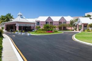 una carretera frente a un edificio rosa en Comfort Suites Paradise Island en Nassau