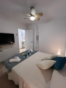 Un dormitorio con una cama grande con ventilador de techo. en Casa Cristina - Playa San Juan, en Playa de San Juan