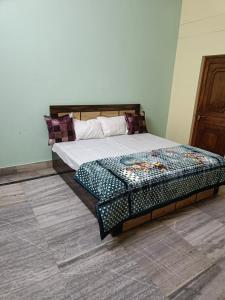 a bedroom with a bed with a wooden headboard at Jai Villa homestay in Prayagraj