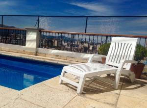 a white chair sitting next to a swimming pool at Solar De La Plaza in Salta