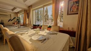 jadalnia ze stołem i krzesłami oraz oknem w obiekcie La Dora Mountain Resort w mieście Divčibare