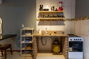 a small kitchen with a sink and a stove at Pituba Ville - Ap 1 - 2 Quartos in Itacaré
