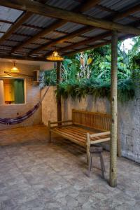 a wooden bench in a pavilion with a hammock at Pituba Ville - Ap 1 - 2 Quartos in Itacaré