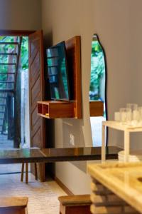 a table with a tv and a mirror at Pituba Ville - Ap 1 - 2 Quartos in Itacaré +48 photos