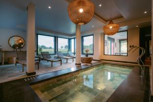 a swimming pool in a house with two chandeliers at Haras Santa María del Mar in Mar del Plata