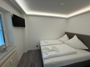 a room with a bed with white pillows on it at Residenz Rügen im Haus Windland in Dranske