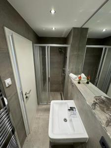 a bathroom with a white sink and a shower at Residenz Rügen im Haus Windland in Dranske