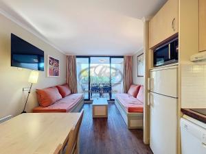 ein Wohnzimmer mit Couch und Kühlschrank in der Unterkunft Appartement 4 personnes vue mer résidence pierre et vacances à Pramousquier in Rayol-Canadel-sur-Mer